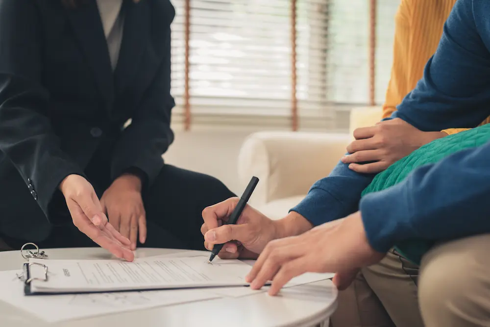 Twee personen ondertekenen een document over een aansprakelijkheidsverzekering.