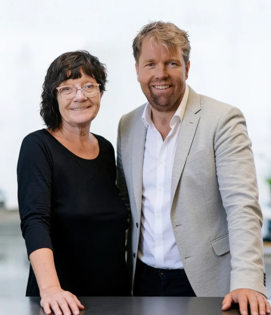 Een glimlachende man en vrouw staan samen aan een tafel.